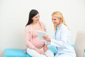 Eine schwangere Frau unterhält sich mit ihrer Frauenärztin.